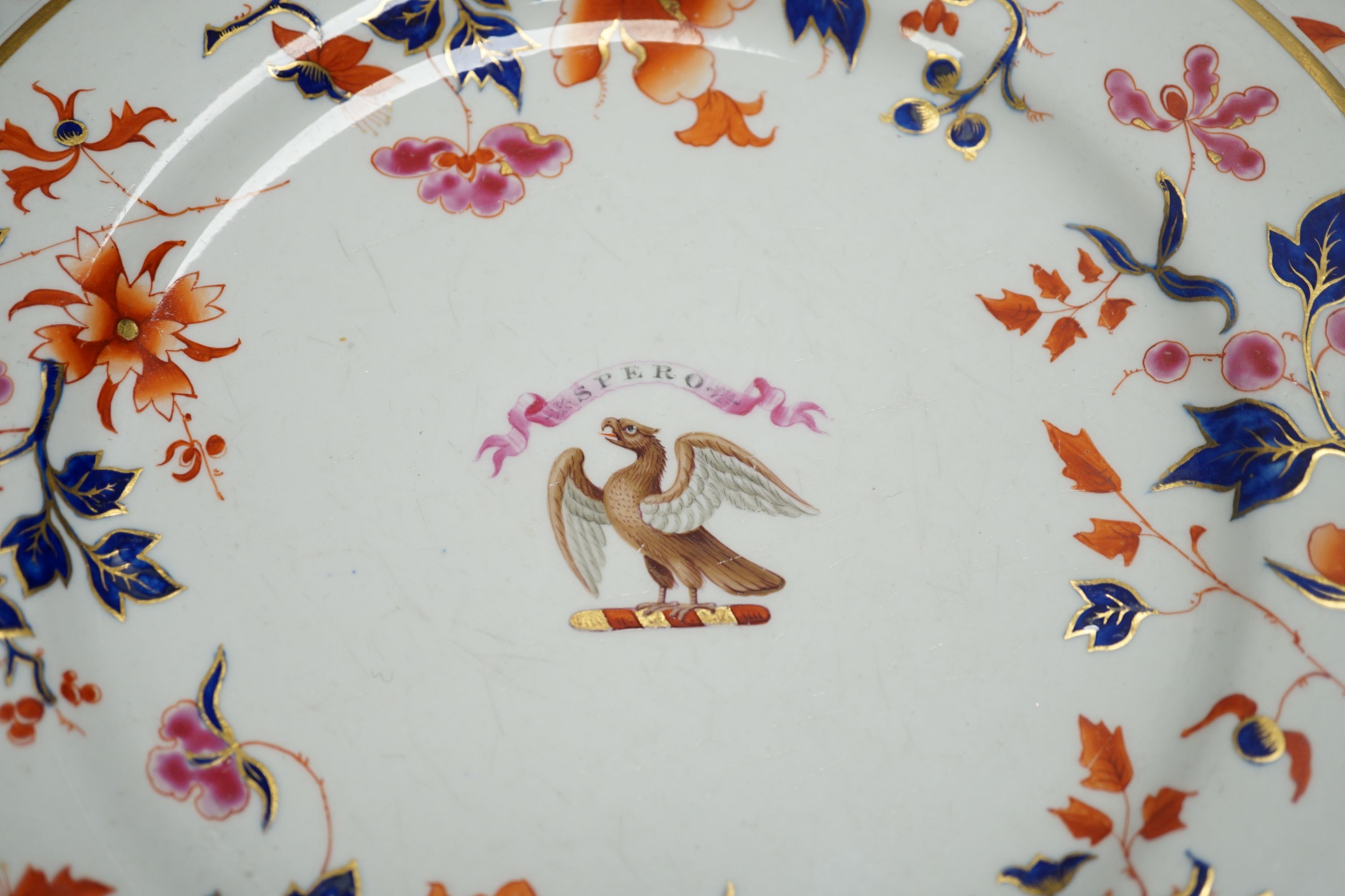 A Flight Barr and Barr set of three armorial plates decorated in imari style with leaves and flowers inscribed on a banner 'SPERO' (hope) above a hawk, c.1820, 26 cms diameter.